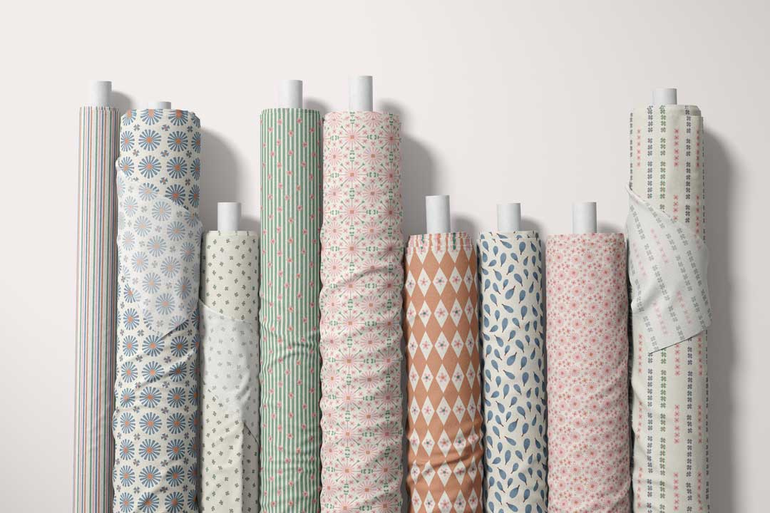 Mediterranean Bloom fabric rolls showing coordinated florals, stripes, leaves, and geometric prints.