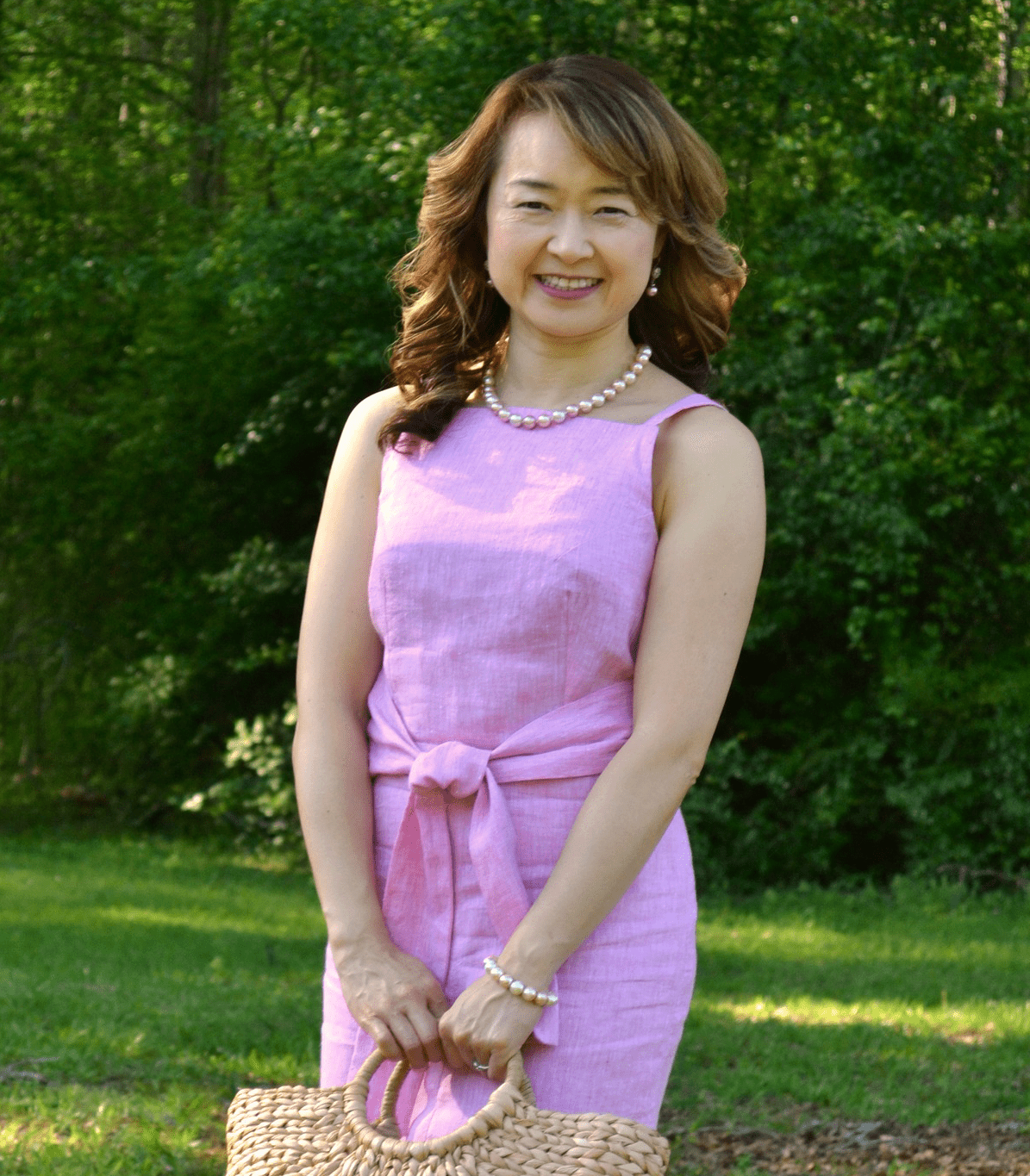 Meg Dixon of Studio Meggi wearing a pink linen dress outdoors, representing soft surface pattern design for kidswear and quilting.